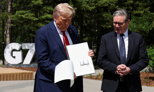 Thủ tướng Anh giải thích việc nhặt giấy tờ dưới chân ông Trump