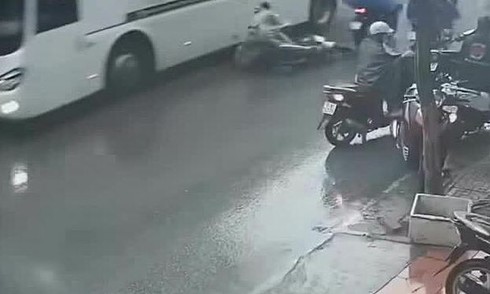 Hai người đi xe máy trượt ngã vào gầm xe khách