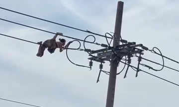 Người phụ nữ vắt vẻo trên dây điện cao 10 m