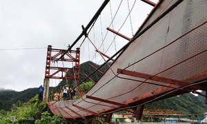 Suspension bridge collapse sends vehicle carrying local officials into river during typhoon
