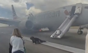 Passengers evacuate burning American Airlines plane