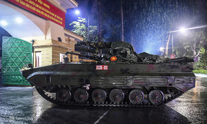 Military vehicles maneuver through Hanoi rain