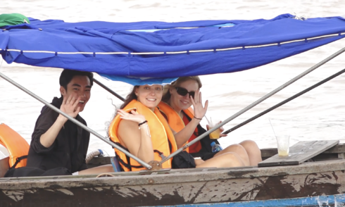 American tourists enjoy fruit and noodles on Cai Rang floating market boats