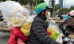 Hanoi residents use plastic bags to ward off early season chill