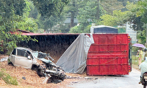 Container overturns, crushes car, three critically injured