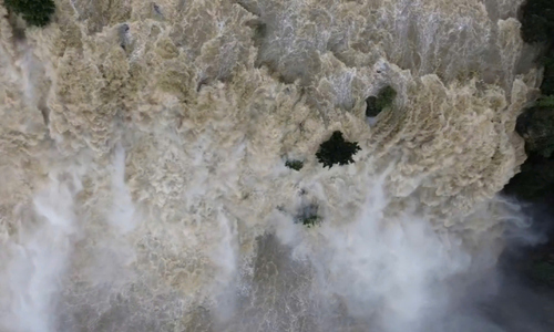 Pongour waterfall rages with murky floodwaters