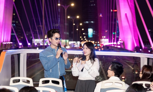 Young people experience night photography in TP HCM on a double-decker bus