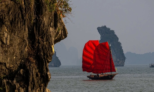Red sailboats appear, drawing attention in Ha Long Bay