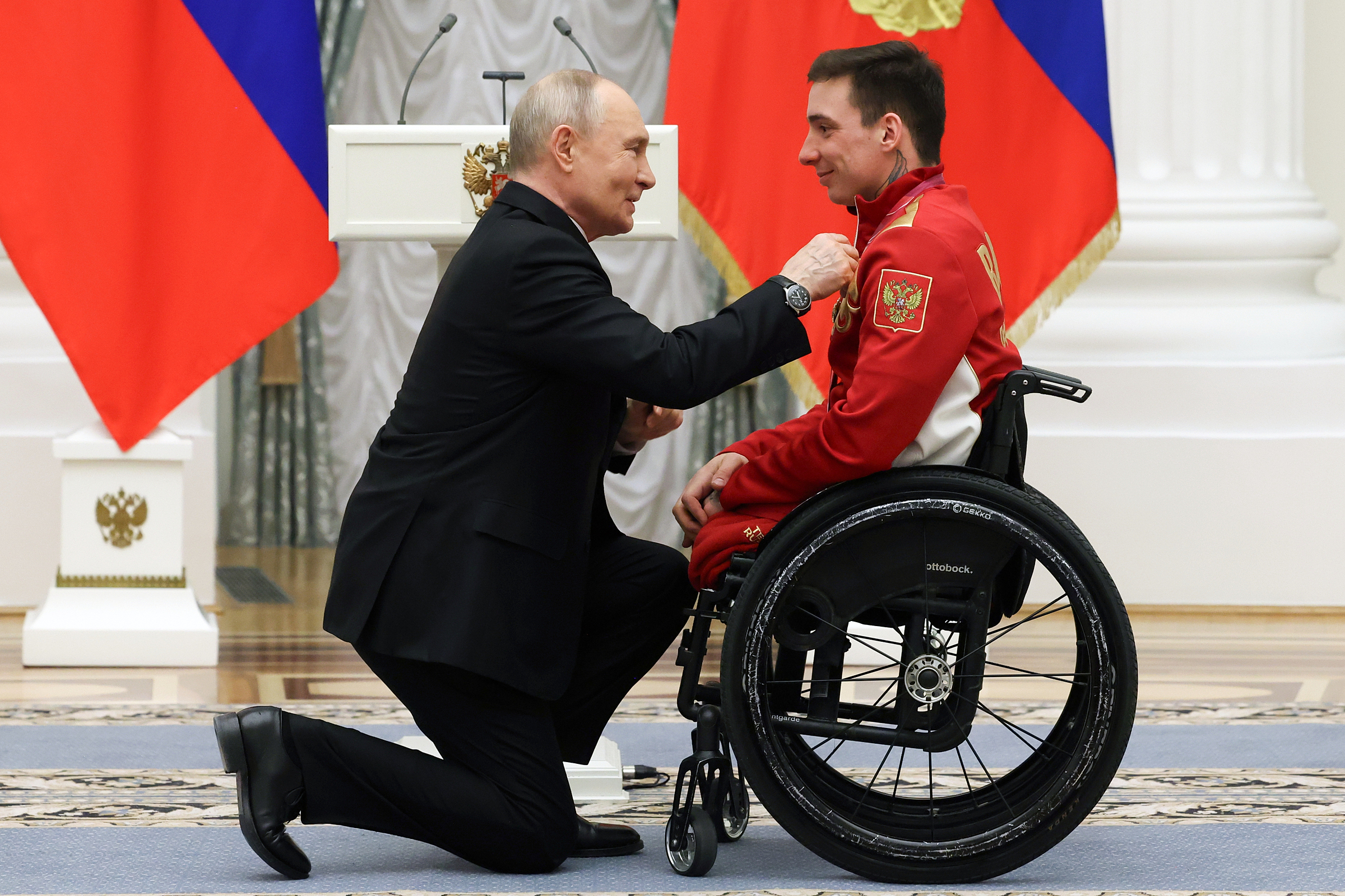 President Putin kneels on one knee to award medal to disabled athlete