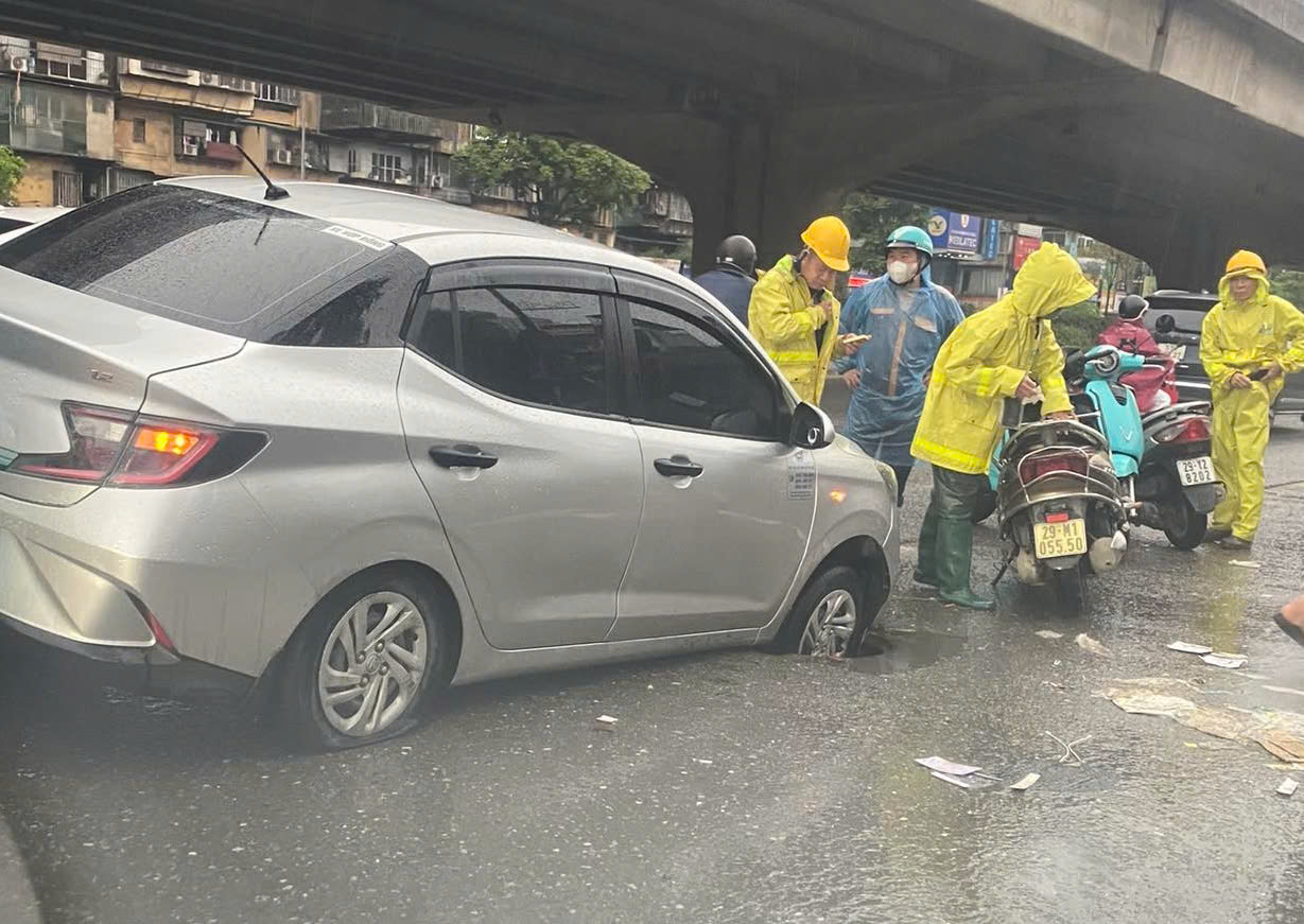 Taxi's front wheel plunges into deep hole on Hanoi street