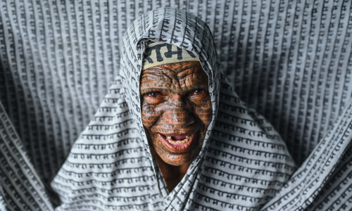 Indian community tattoos divine names across their faces