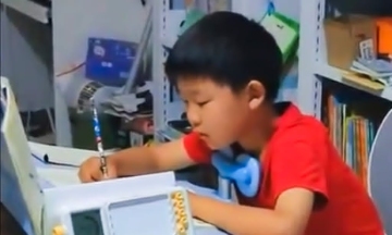 Boy pedals sewing machine while doing homework
