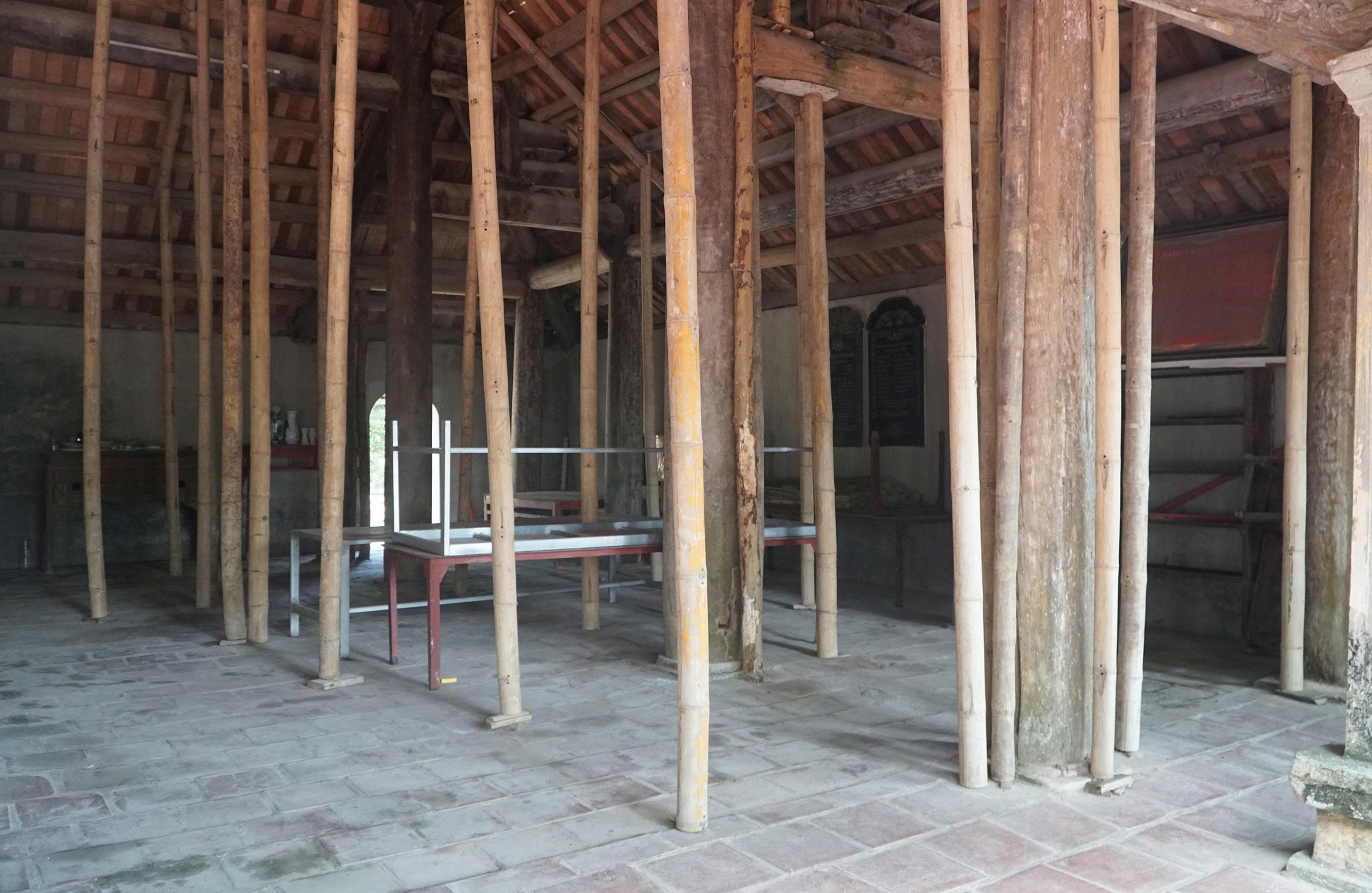 Bamboo poles prop up ancient communal house facing collapse