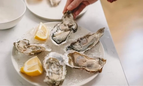 Does squeezing lemon on raw oysters kill bacteria?