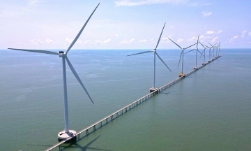 Sea bridge in Ca Mau offers visitors views of a wind farm