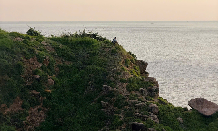 Male tourist climbs Mui Dien cliff for photos, disregards danger