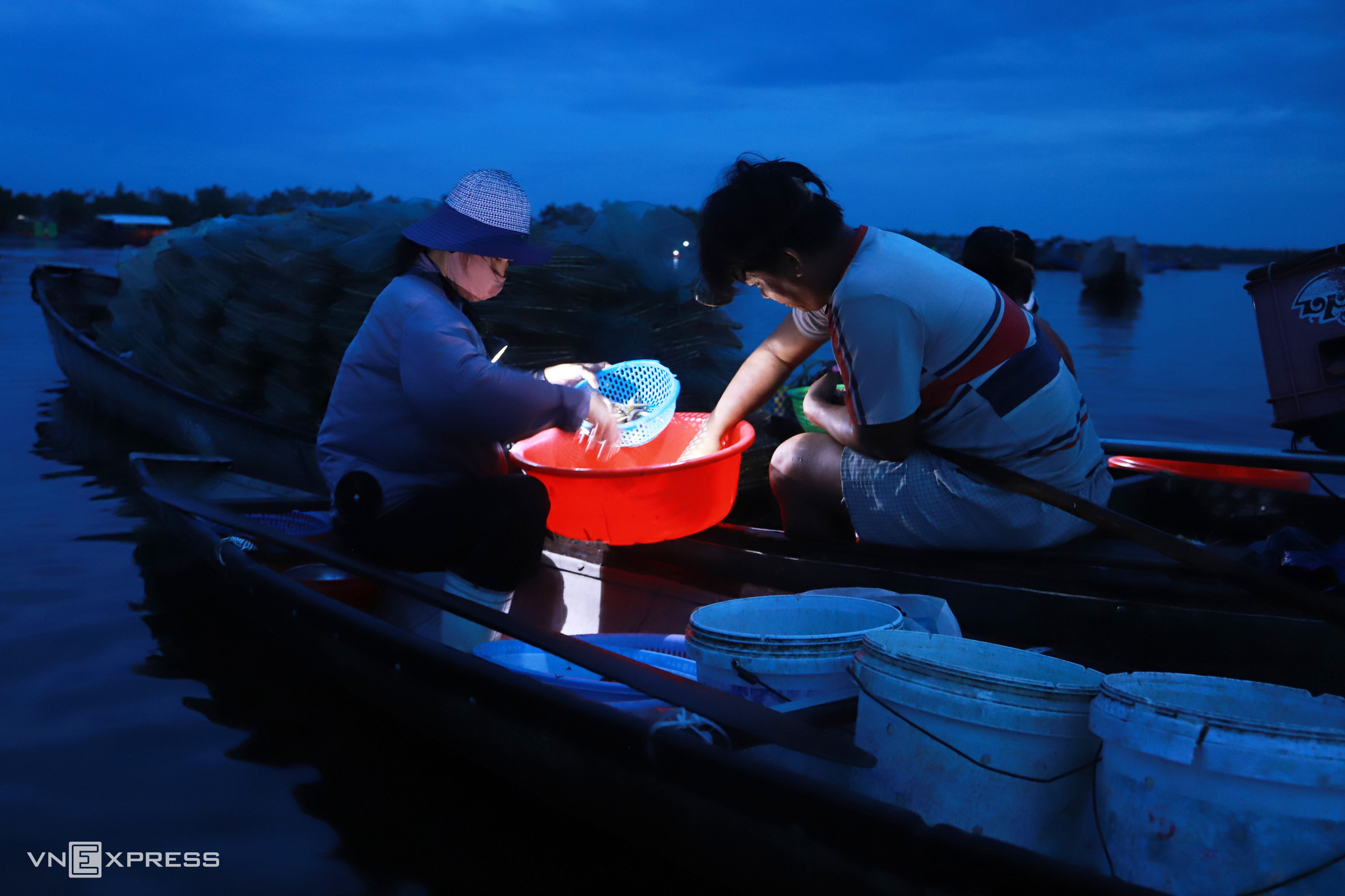 Lights illuminate early morning seafood trade on Tam Giang Lagoon floating market