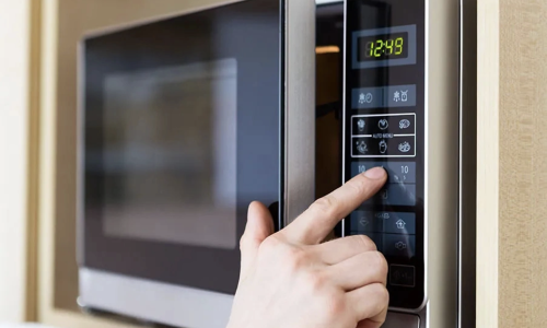 Does standing close to or looking directly into a running microwave oven cause cancer?