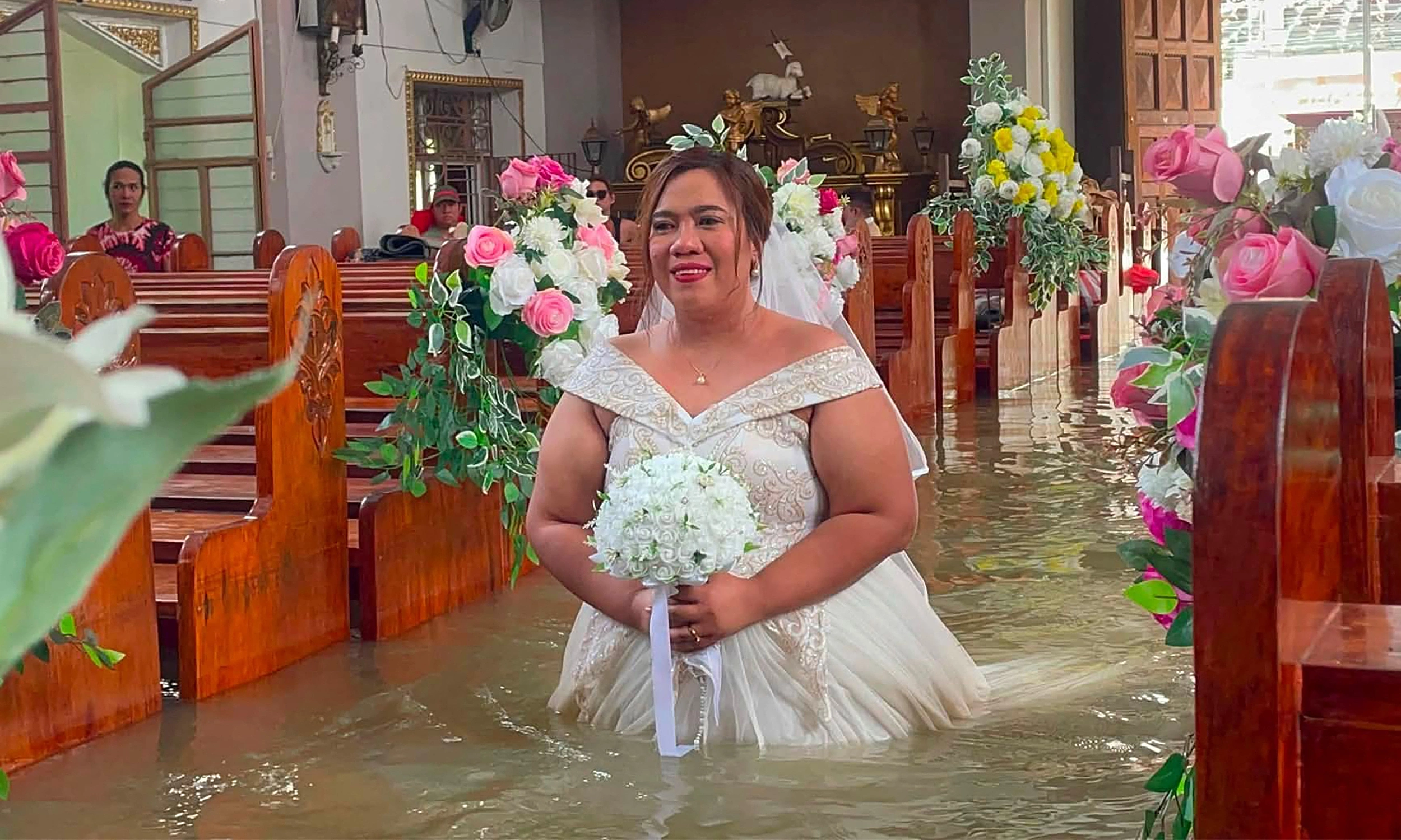 Bride wades through waist-deep floodwaters to the altar