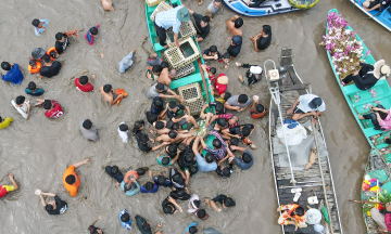 Mekong Delta's floating season: field bathing, boat racing, and duck catching