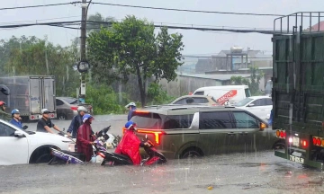 Water submerges car wheels on many roads in Ho Chi Minh City