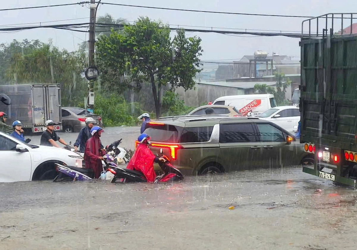 Water submerges car wheels on many roads in Ho Chi Minh City