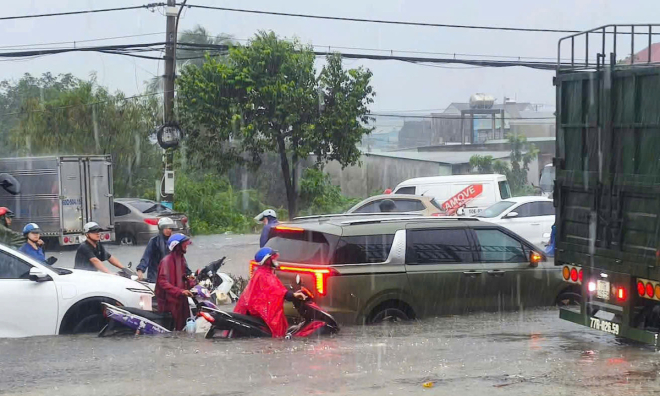 Water submerges car wheels on many roads in Ho Chi Minh City